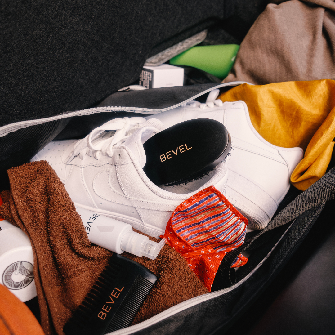 White sneakers with BEVEL branding in a suitcase with clothes.