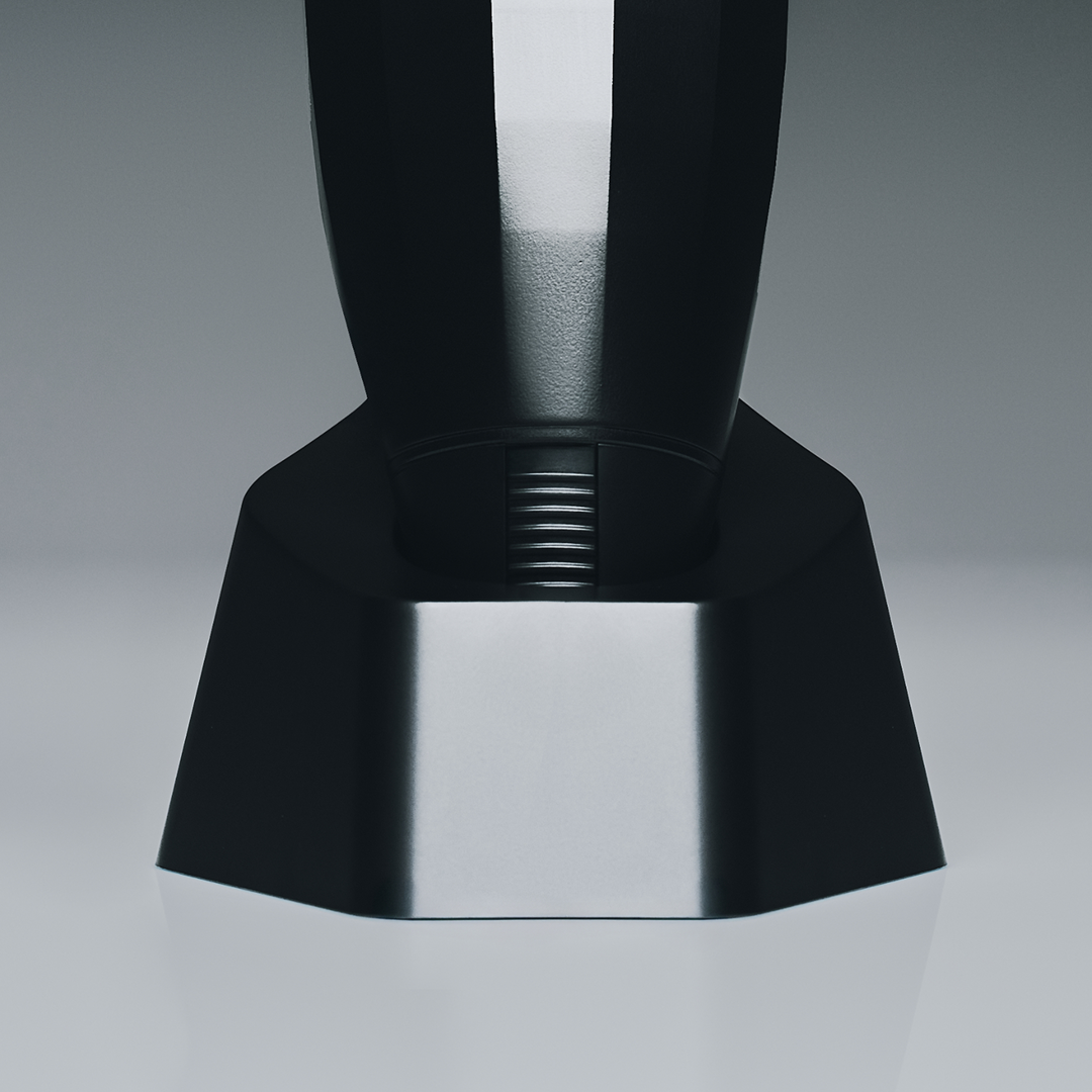 Close-up of a black and silver coffee grinder on a gray background