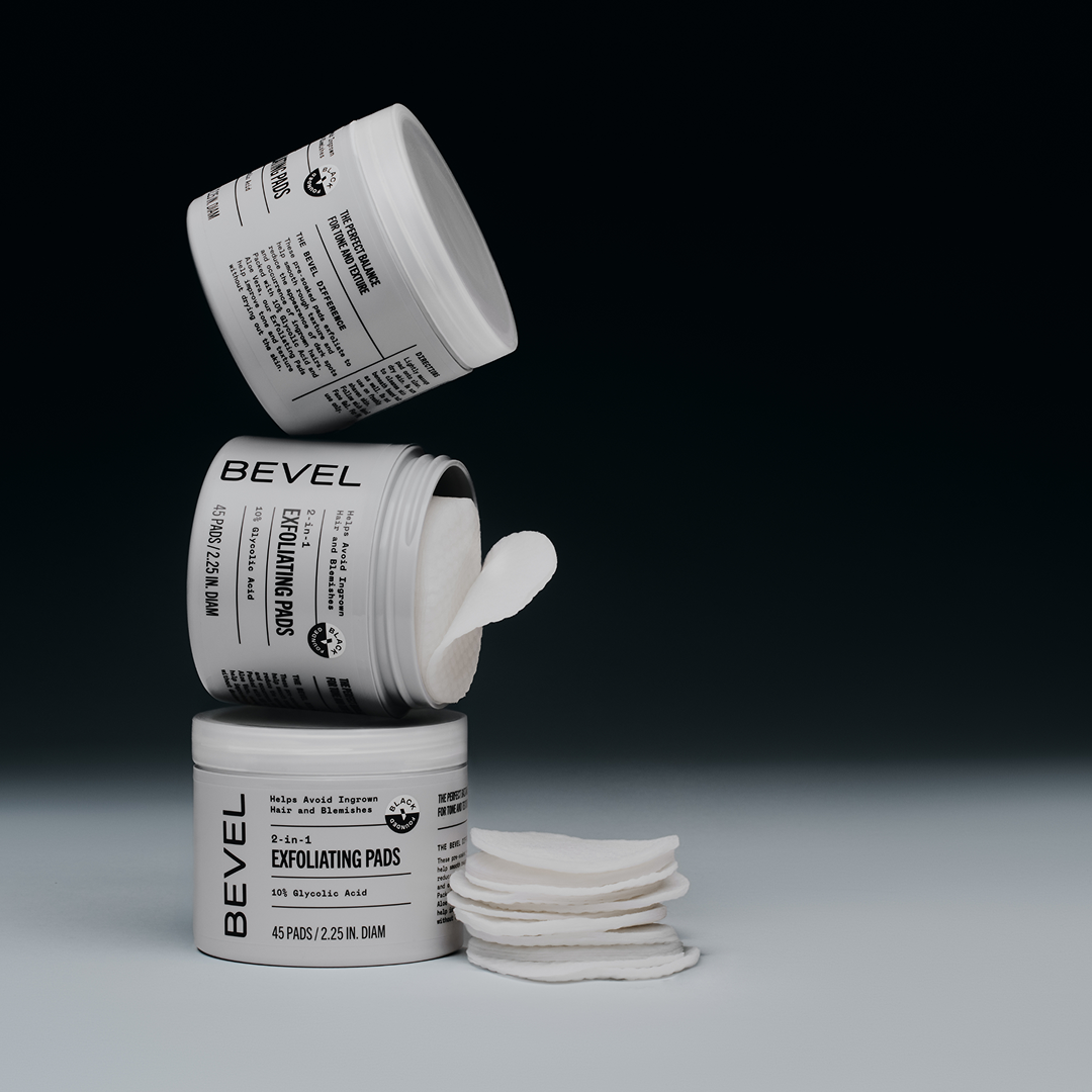 Three containers of Revel Exfoliating Pads with a stack of pads on a gray background