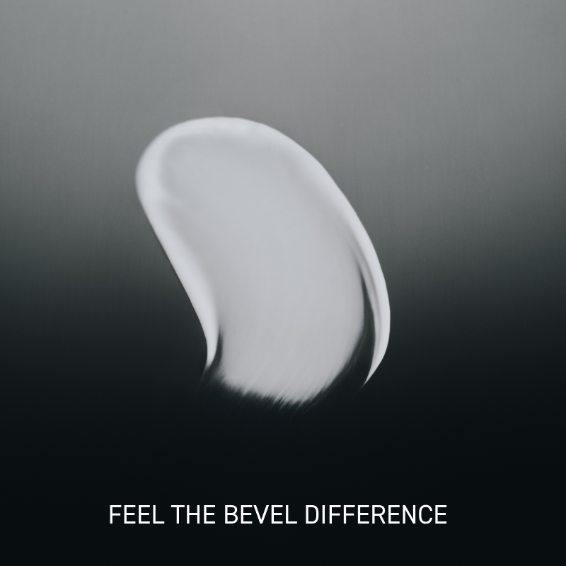 White cosmetic product smear on a dark background with 'Feel the Bevel Difference' text.