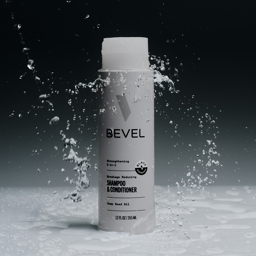 Bevel shampoo and conditioner bottle with water splashes on a dark background