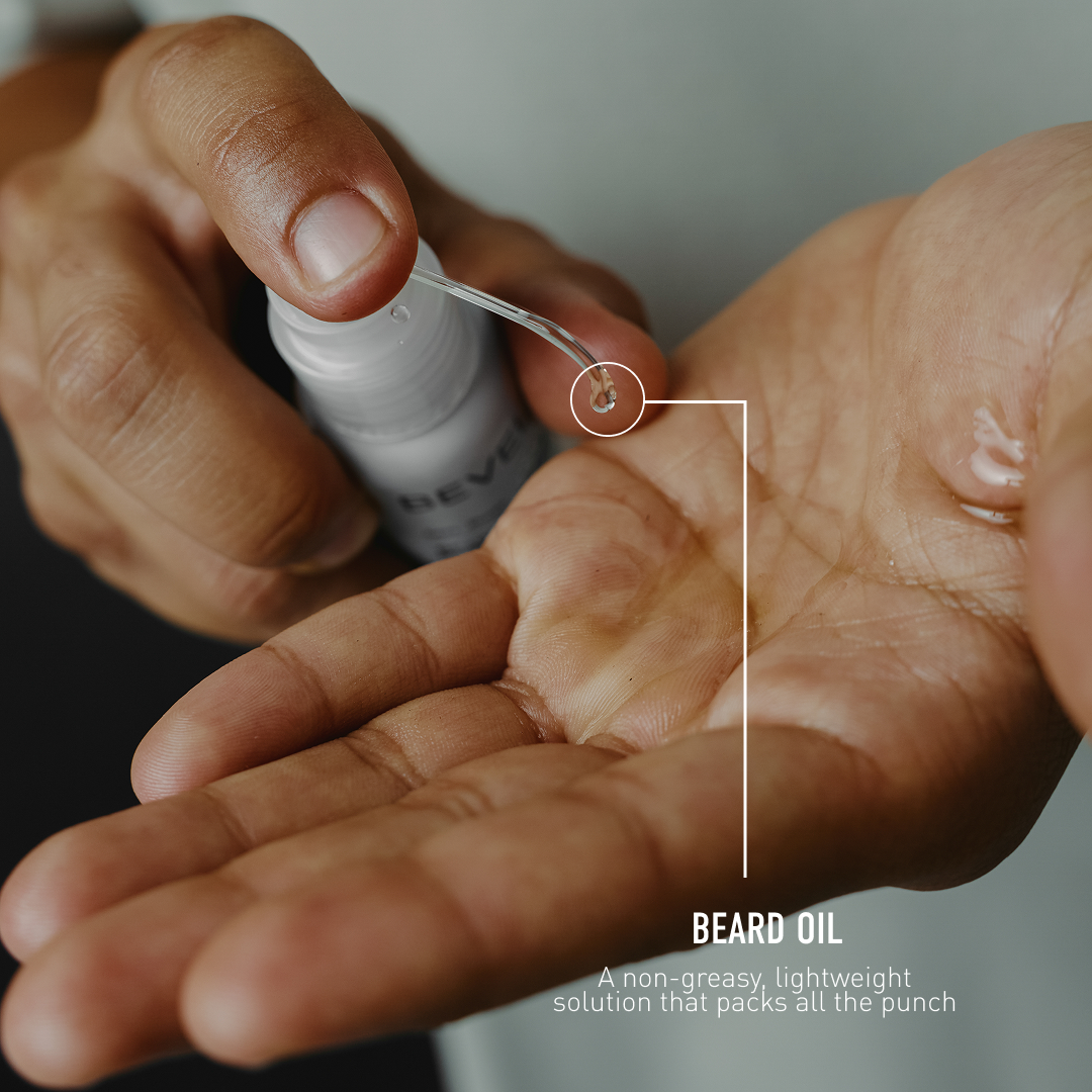 Person applying beard oil to their hand with a dropper bottle.