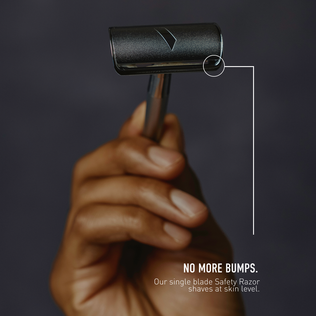 Hand holding a safety razor with text 'No More Bumps' on a dark background