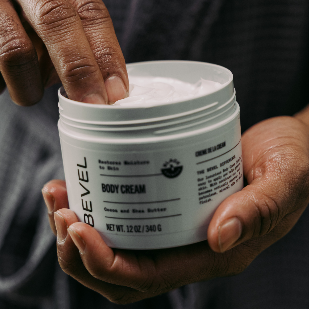Person holding a jar of BEVEL body cream with visible text on the label.